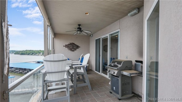 view of patio / terrace featuring ceiling fan, a water view, a balcony, and grilling area