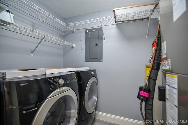 washroom with water heater, electric panel, and washer and dryer