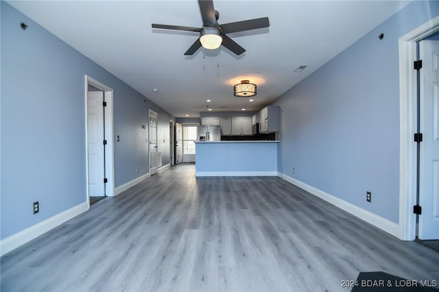 unfurnished living room with hardwood / wood-style floors and ceiling fan