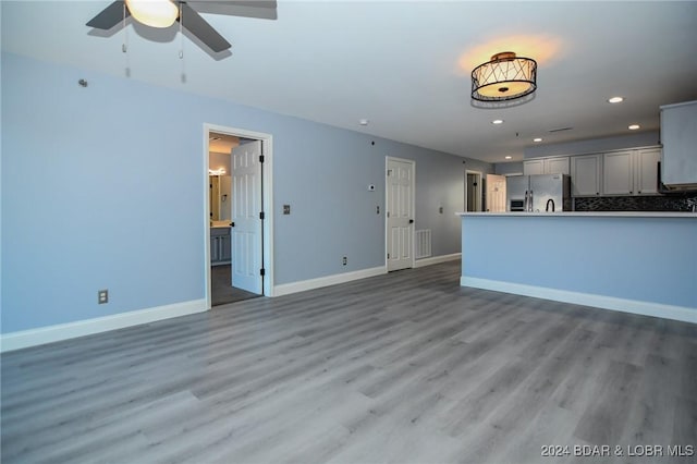 unfurnished living room with hardwood / wood-style floors and ceiling fan