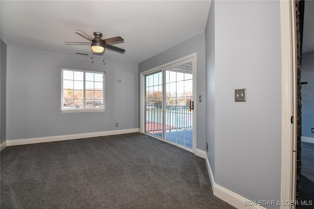 carpeted empty room with ceiling fan and a wealth of natural light