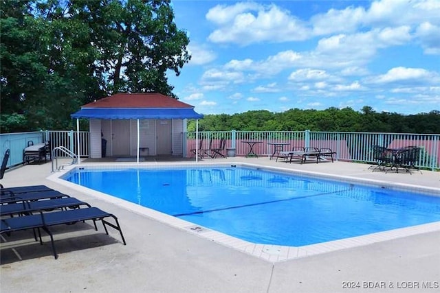 pool with fence and a patio area