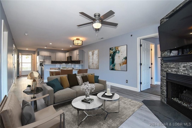 living room with dark hardwood / wood-style flooring, a fireplace, and ceiling fan