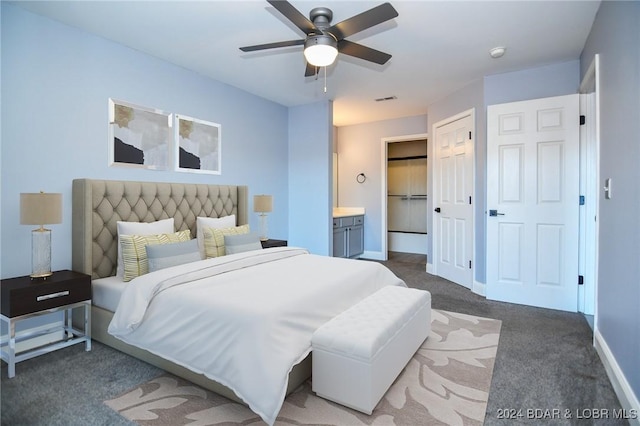 bedroom with connected bathroom, dark carpet, and ceiling fan