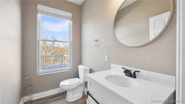 bathroom with hardwood / wood-style floors, vanity, and toilet