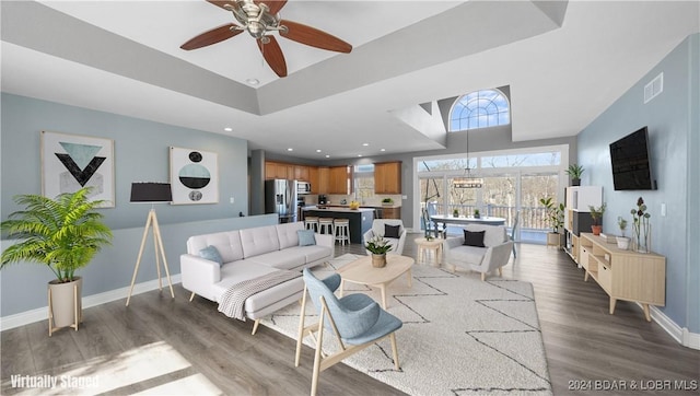 living room featuring ceiling fan and dark hardwood / wood-style flooring