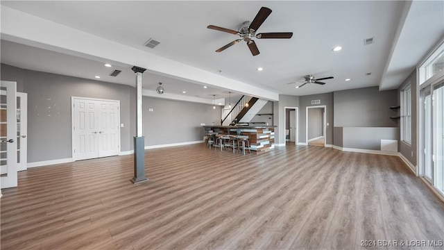 unfurnished living room with light wood-type flooring and ceiling fan