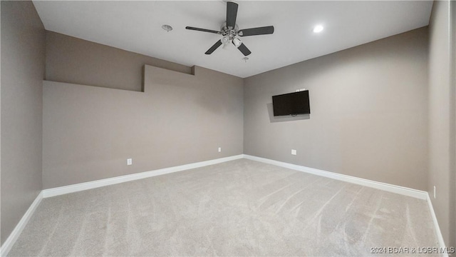 carpeted spare room featuring ceiling fan