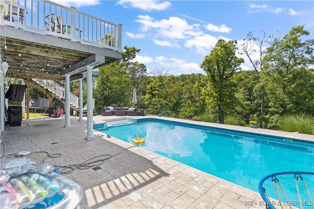 view of pool featuring outdoor lounge area, a deck, and a patio area