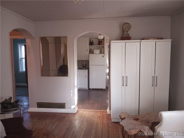 kitchen with hardwood / wood-style flooring, white fridge, and crown molding