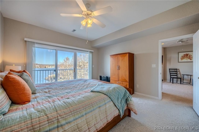 bedroom featuring access to outside, light colored carpet, ceiling fan, and a water view