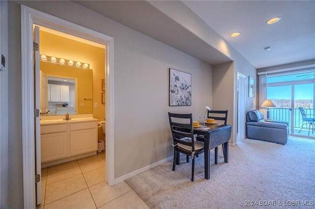 dining area with sink and light colored carpet