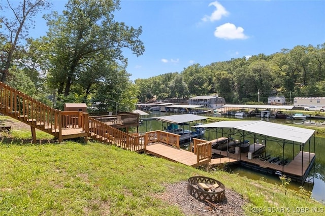 view of yard featuring a dock, a water view, and a fire pit