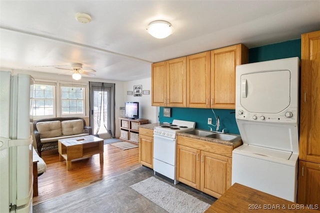 kitchen with white range oven, ceiling fan, sink, stacked washer / dryer, and dark hardwood / wood-style floors