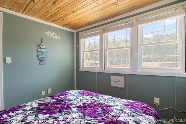 bedroom with crown molding and wood ceiling