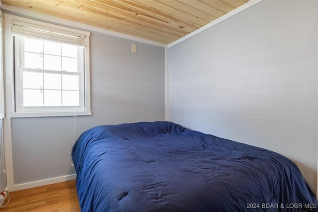 bedroom with wood-type flooring, lofted ceiling, ornamental molding, and wood ceiling