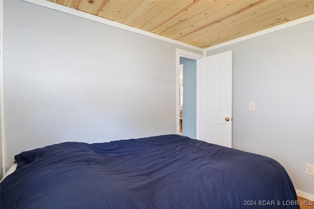 unfurnished bedroom featuring wooden ceiling and crown molding