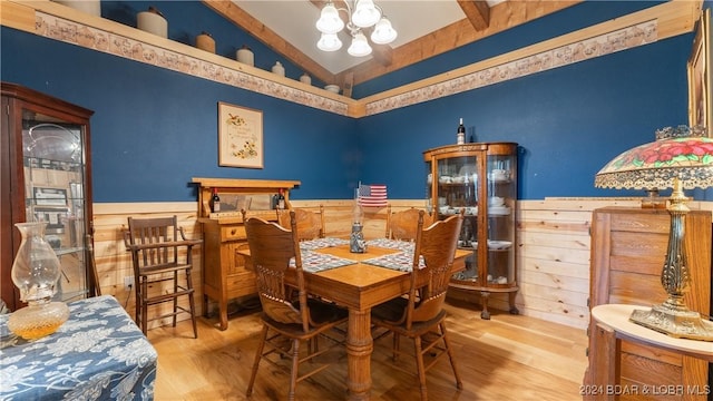 dining space with hardwood / wood-style floors, a notable chandelier, and lofted ceiling