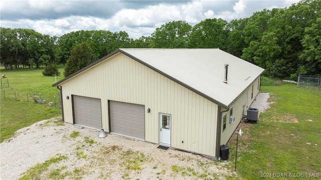 garage with a yard and central air condition unit