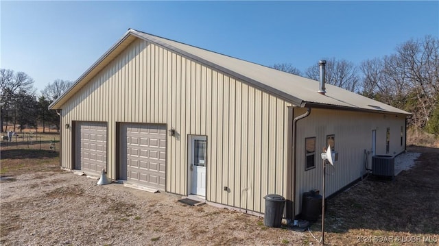 view of side of home featuring an outbuilding, central AC, and a garage