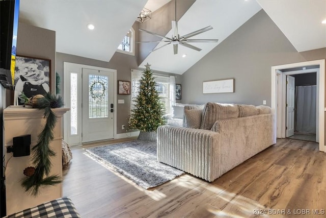 living room with ceiling fan, high vaulted ceiling, and light hardwood / wood-style flooring