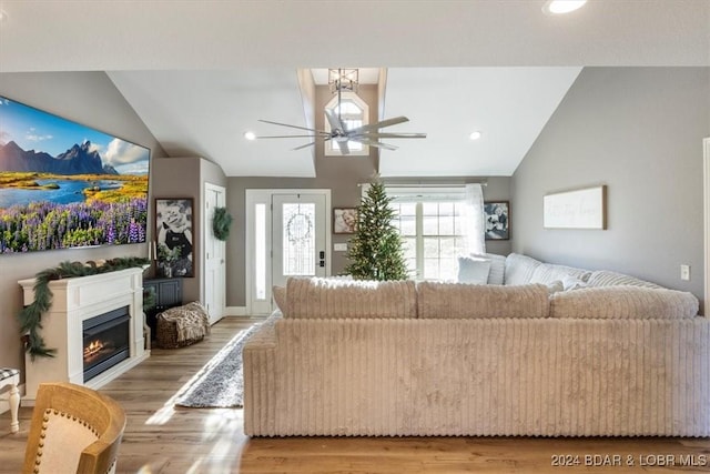 living room featuring ceiling fan, light hardwood / wood-style flooring, and vaulted ceiling