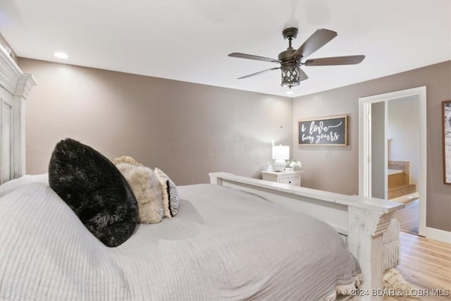 bedroom featuring connected bathroom, ceiling fan, and light hardwood / wood-style flooring