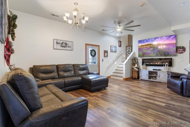 living room with ceiling fan with notable chandelier and dark hardwood / wood-style floors