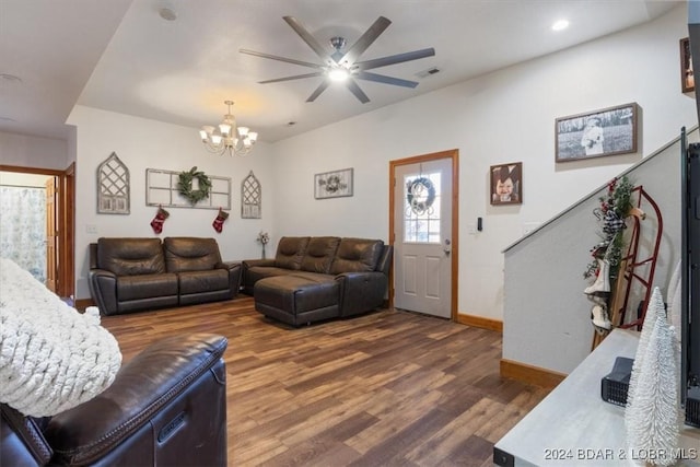 living room featuring ceiling fan with notable chandelier and hardwood / wood-style flooring