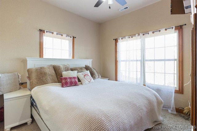 bedroom with carpet flooring, ceiling fan, and multiple windows