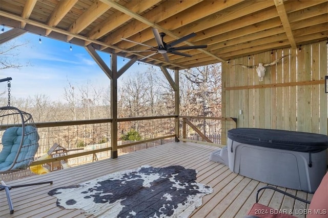 wooden terrace with ceiling fan and a hot tub