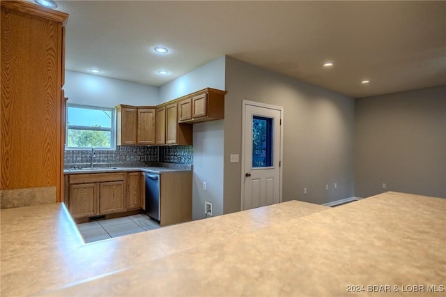 kitchen featuring light tile patterned flooring, tasteful backsplash, stainless steel dishwasher, and sink