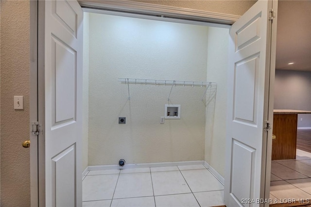 washroom featuring hookup for an electric dryer, light tile patterned floors, and washer hookup