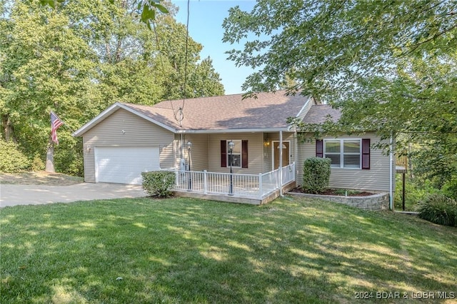 ranch-style home featuring covered porch, a garage, and a front yard