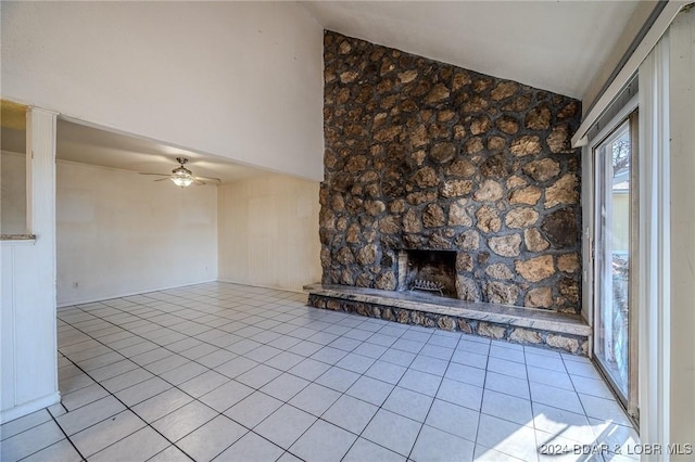 unfurnished living room featuring ceiling fan, light tile patterned flooring, lofted ceiling, and a fireplace