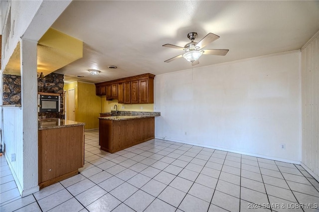 kitchen featuring kitchen peninsula, ceiling fan, sink, light tile patterned floors, and black oven