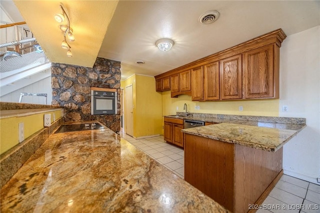 kitchen featuring sink, light tile patterned floors, appliances with stainless steel finishes, stone countertops, and kitchen peninsula