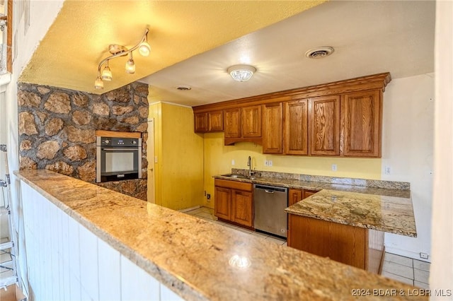 kitchen with light stone counters, light tile patterned floors, sink, and appliances with stainless steel finishes