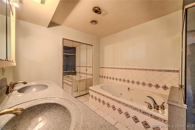 bathroom featuring vanity, tile patterned floors, and tiled tub