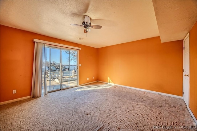 empty room with carpet, ceiling fan, and a textured ceiling