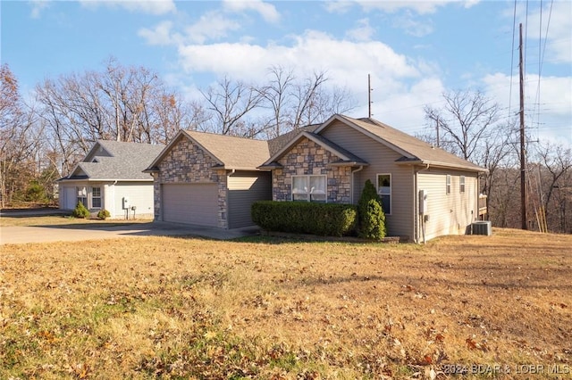 single story home featuring a garage and central AC unit