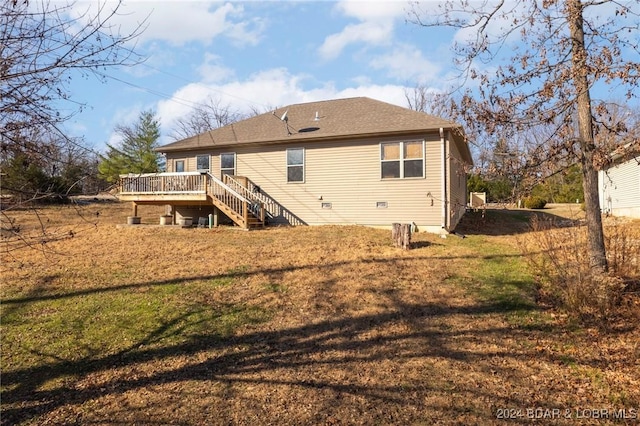 back of house with a deck and a yard