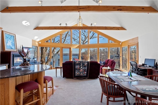 carpeted dining room featuring high vaulted ceiling and beam ceiling