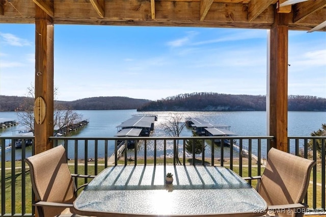 balcony with a dock and a water view