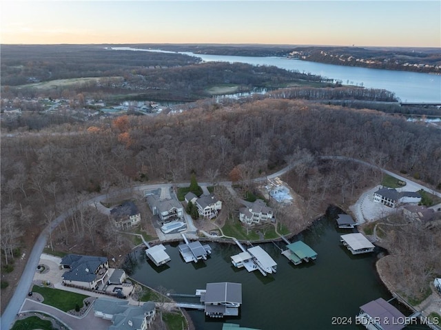 aerial view at dusk featuring a water view