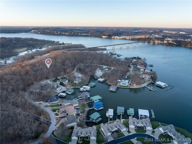 aerial view at dusk featuring a water view