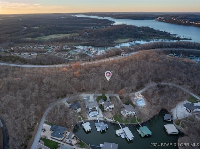 aerial view at dusk featuring a water view