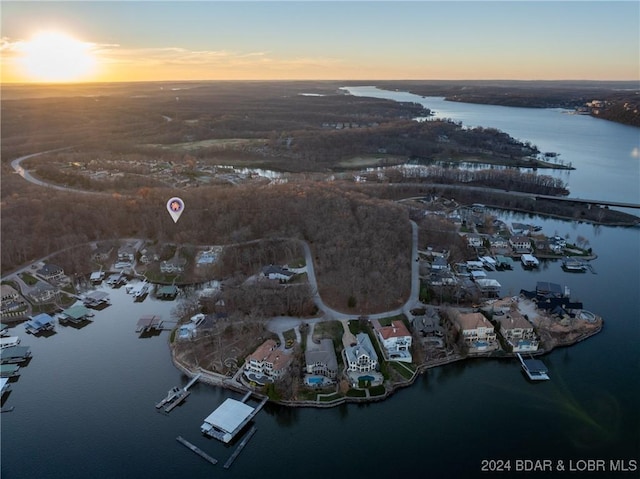 aerial view at dusk featuring a water view