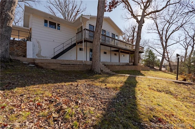 back of property with a wooden deck and a yard