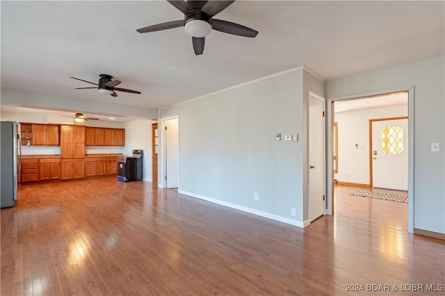 unfurnished living room with light hardwood / wood-style flooring, ceiling fan, and ornamental molding